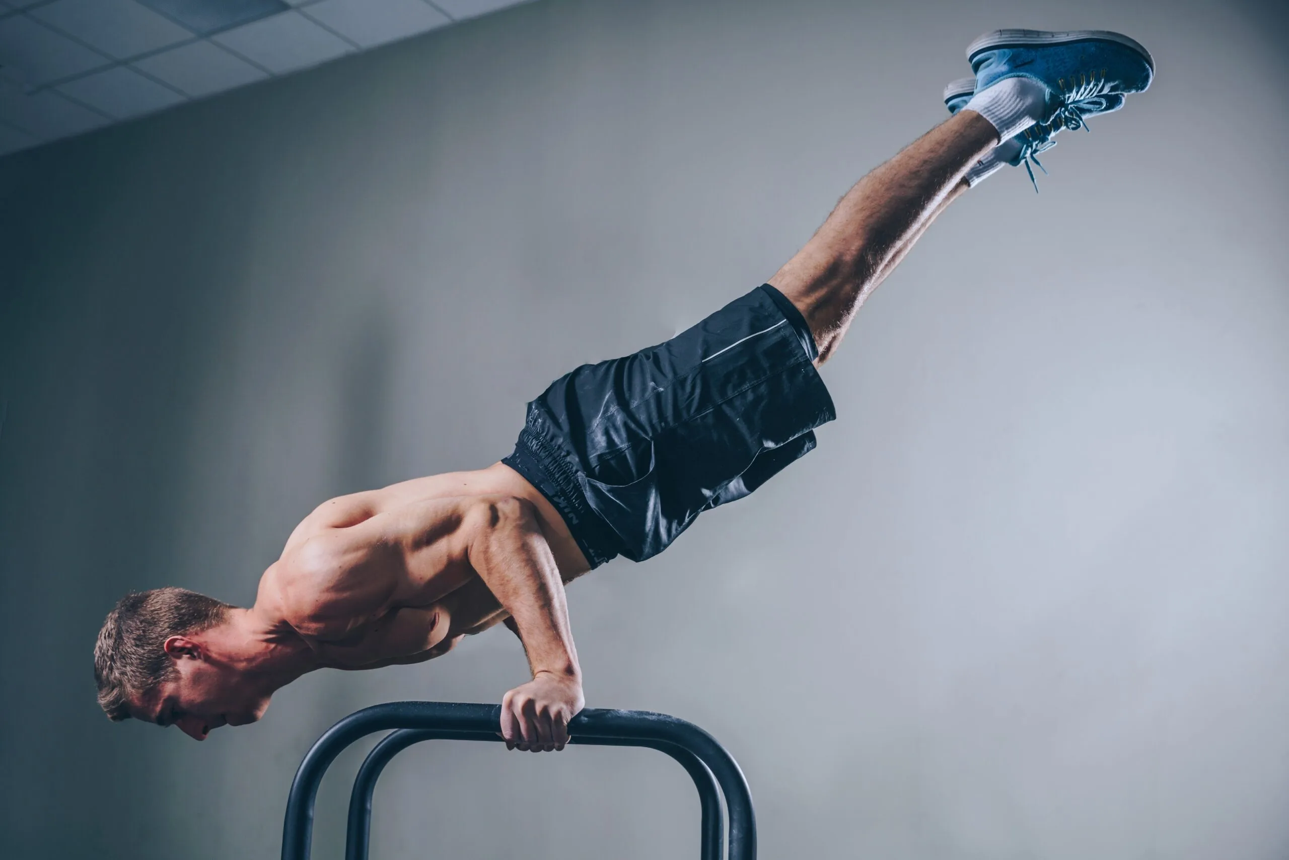 A man balancing on parallel bars, demonstrating exercises to improve coordination and longevity.