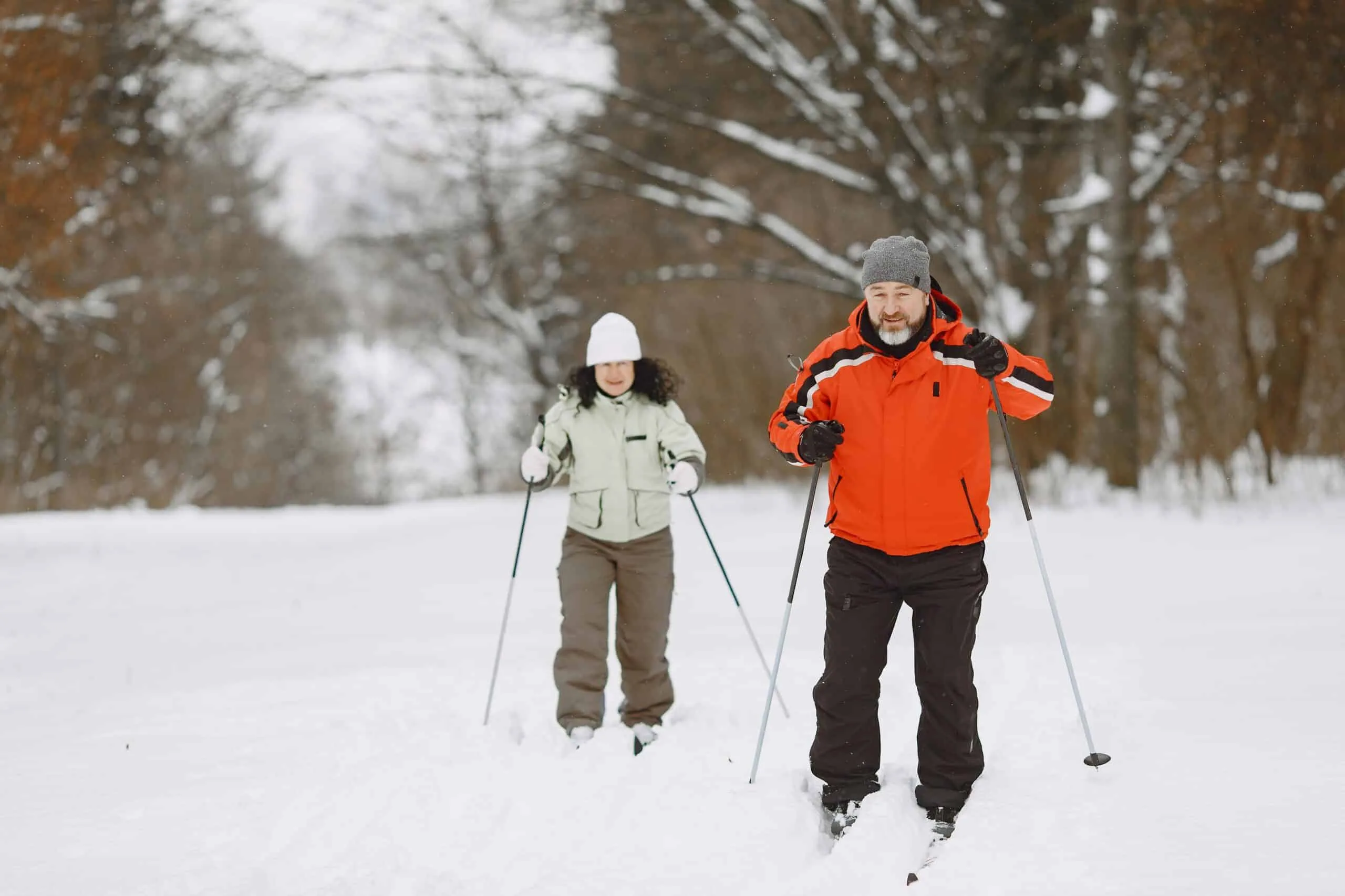 An older couple cross-country skiing, demonstrating how outdoor exercise supports longevity training, longevity exercise, and cardiovascular health.