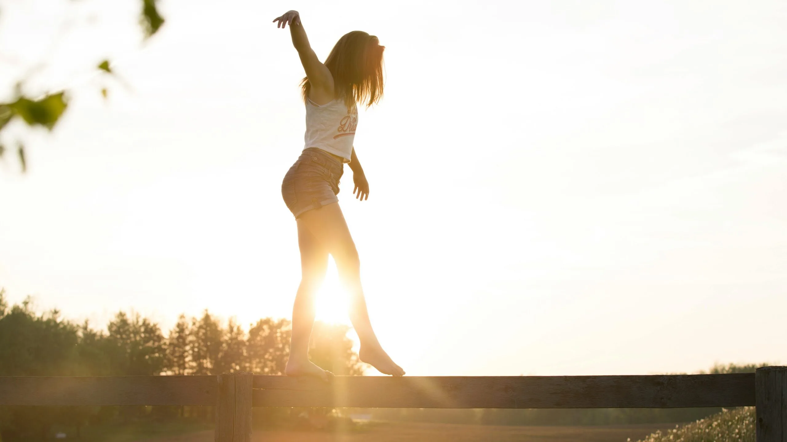 A person balancing during sunset, highlighting the importance of stability in longevity exercises.