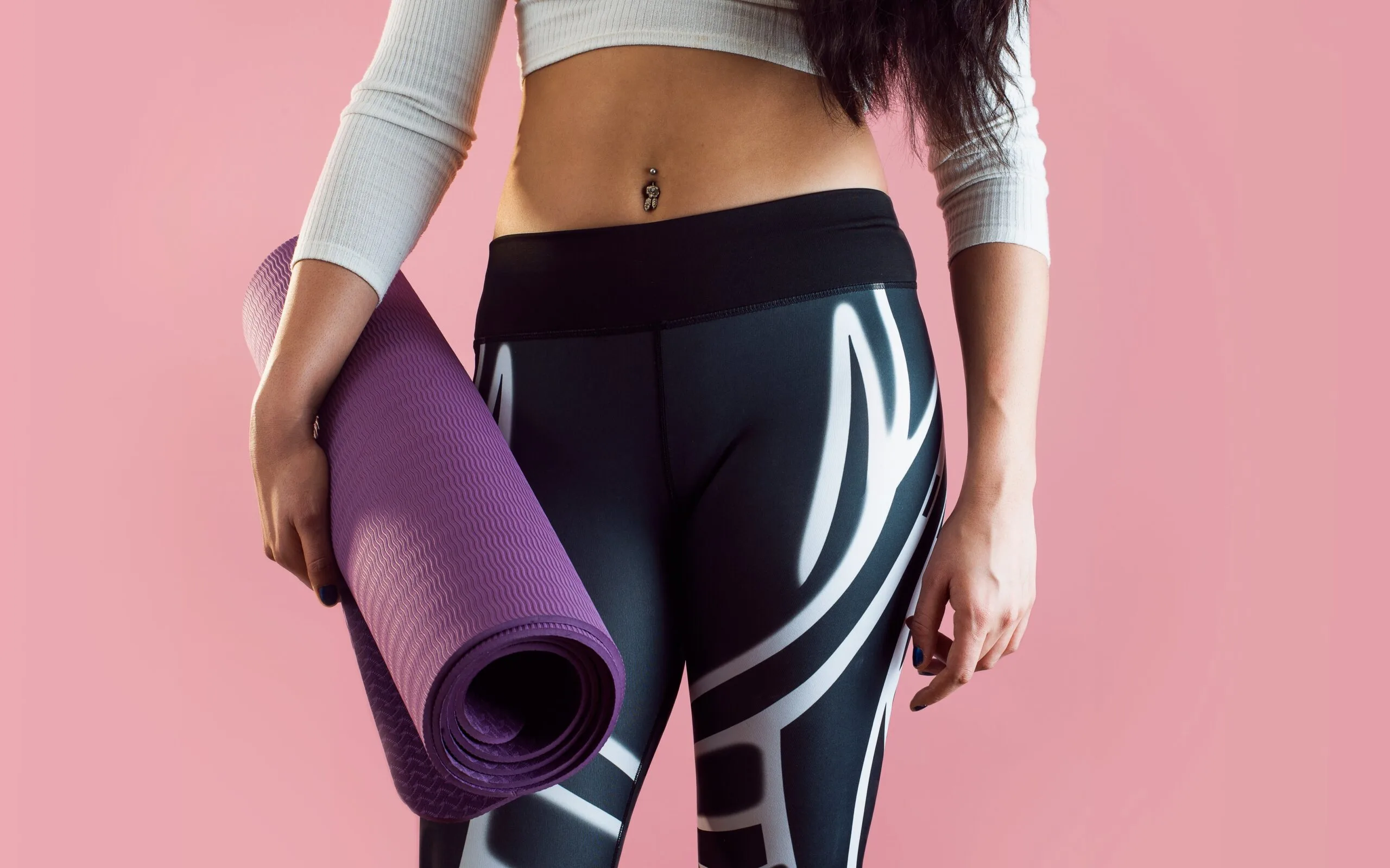 A woman holding a yoga mat, showcasing yoga as part of a longevity training routine.