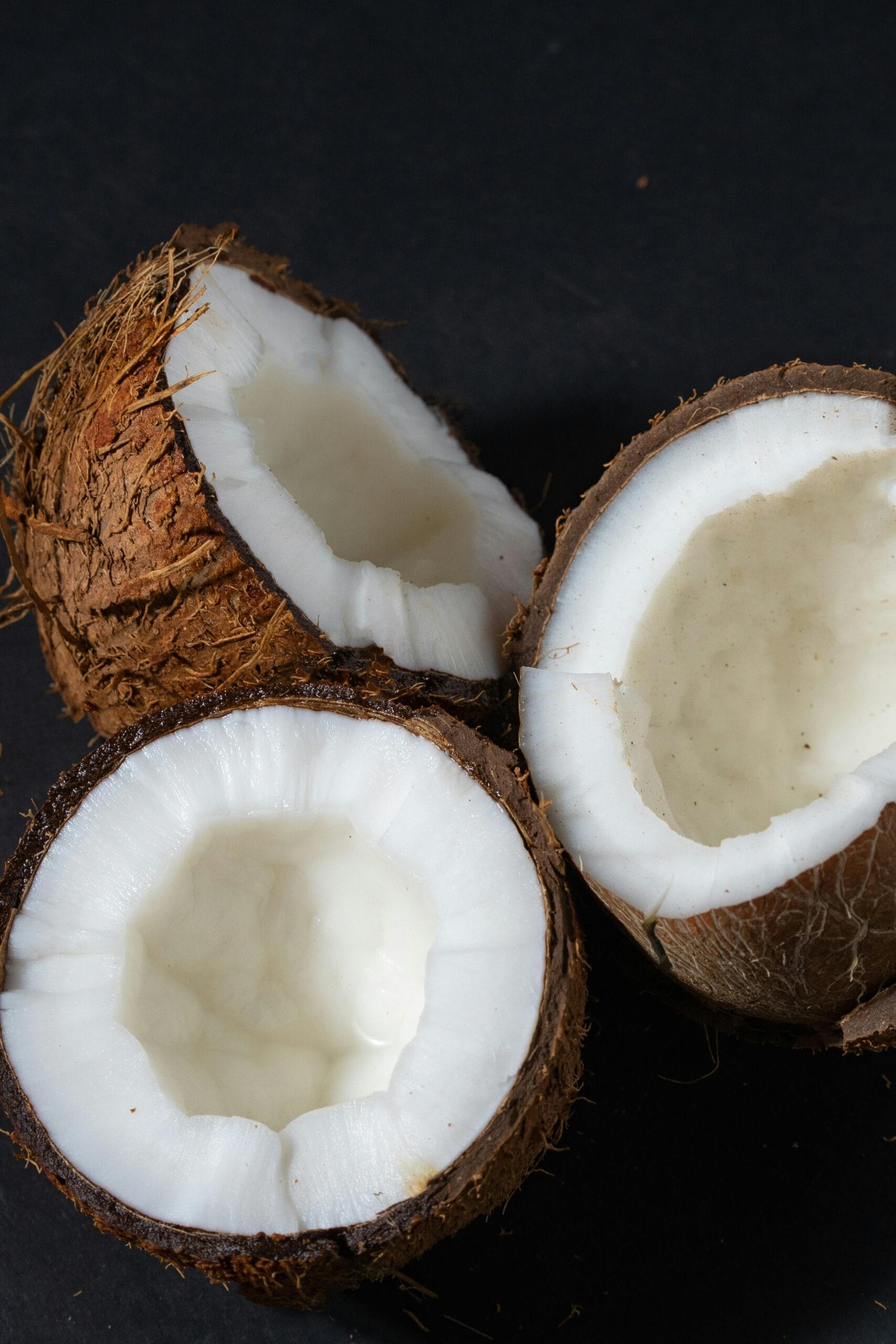 inflammatory-foods-coconut-saturated-fats Close-up of split coconuts, highlighting saturated fats as a potential inflammatory food.