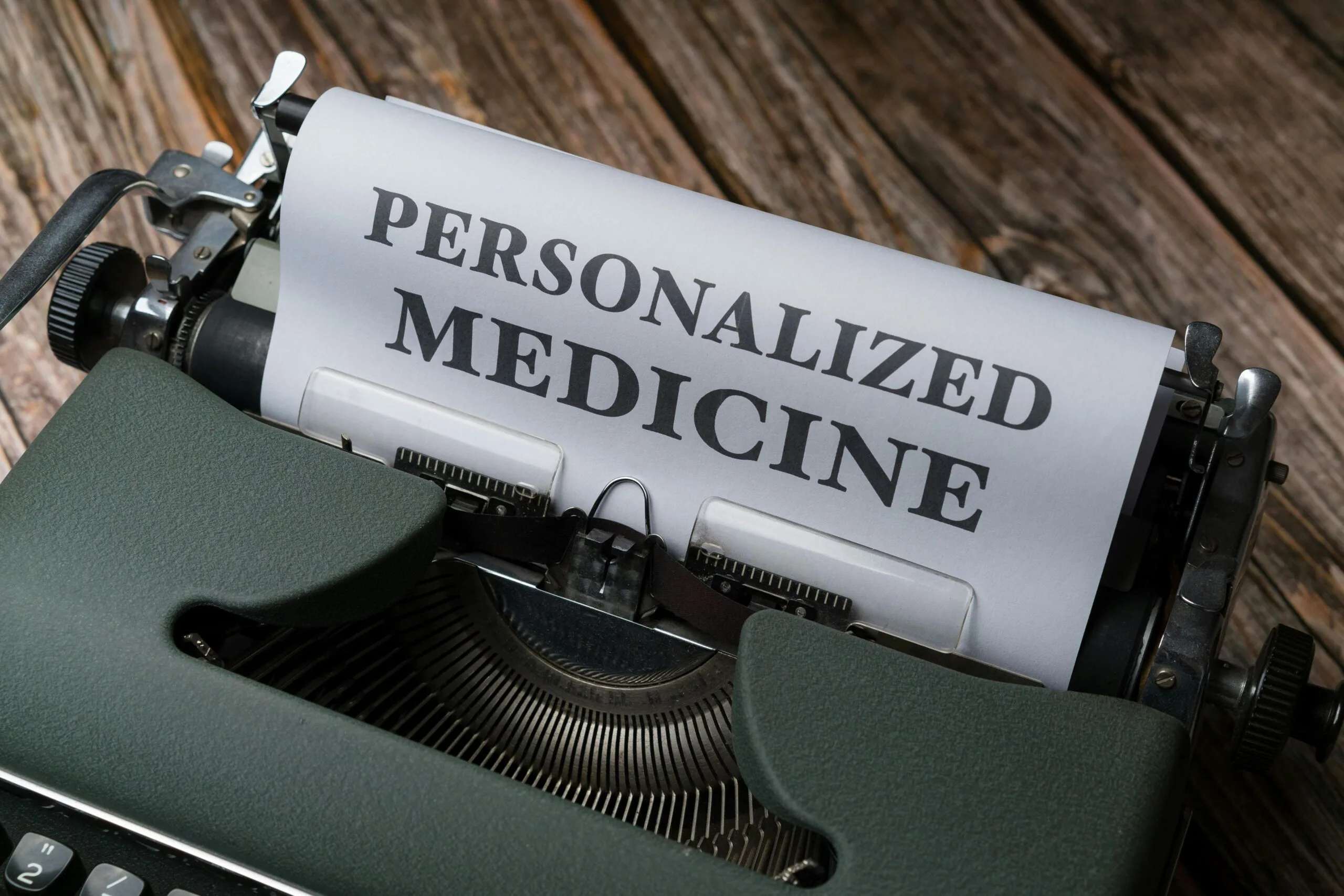 personalized medicine typewriter scaled Vintage typewriter with paper reading “PERSONALIZED MEDICINE” on wooden table